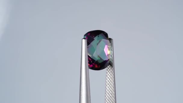 回転テーブルのツイーザーにある天然の虹水晶の宝石 — ストック動画