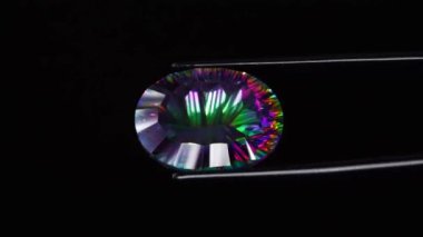 Dönen masanın üzerinde cımbızla doğal gökkuşağı kuvars taşı