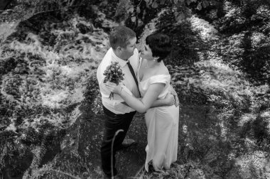 Gelin ve damat bir şelalenin arka planında dururlar.