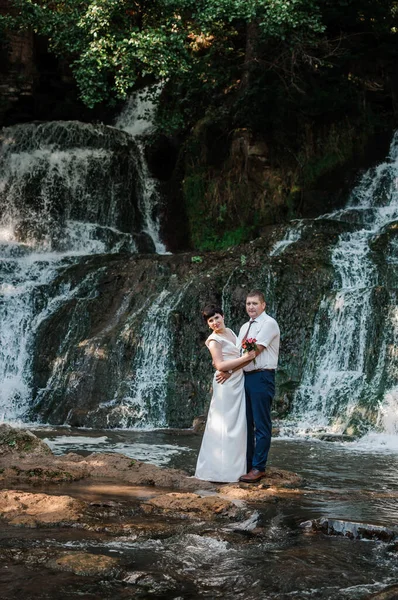 Das Brautpaar Steht Vor Dem Hintergrund Eines Wasserfalls — Stockfoto
