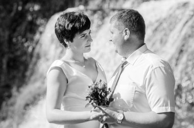 Şelalenin arka planında yeni evliler