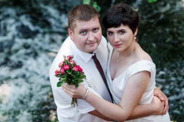 Şelalenin arka planında yeni evliler