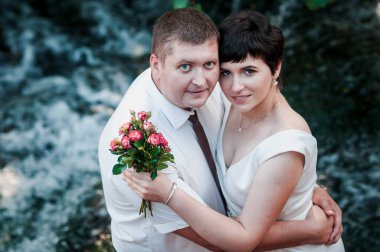 Şelalenin arka planında yeni evliler