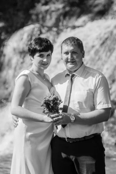 在瀑布背景下的新婚夫妇 — 图库照片