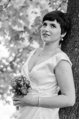 Beyaz elbiseli bir kız şelalenin arka planında duruyor.