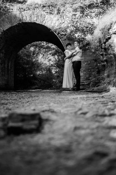 Novomanželé Objímají Líbají Pozadí Vody Kamenného Oblouku — Stock fotografie