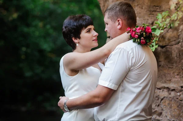 Pasgetrouwden Knuffelen Kussen Tegen Achtergrond Van Water Een Stenen Boog — Stockfoto