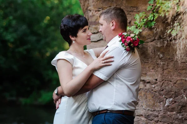 Recém Casados Abraçar Beijar Contra Fundo Água Arco Pedra — Fotografia de Stock