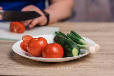 Tomatoes and cucumbers on a white plate on the table