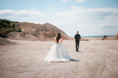 Yeni evliler kumlu bir taş ocağında yürür.