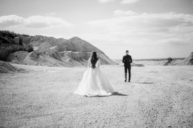 Yeni evliler kumlu bir taş ocağında yürür.