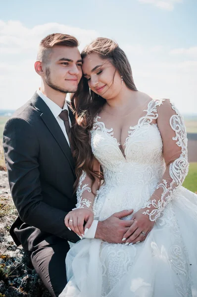 Recém-casados abraçar no fundo das rochas e uma bela paisagem — Fotografia de Stock