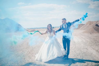 Erkek ve kız sarılır ve renkli dumanı ellerinde tutarlar.