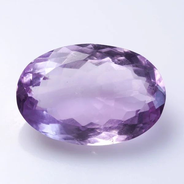 Piedra natural amatista púrpura sobre un fondo blanco —  Fotos de Stock