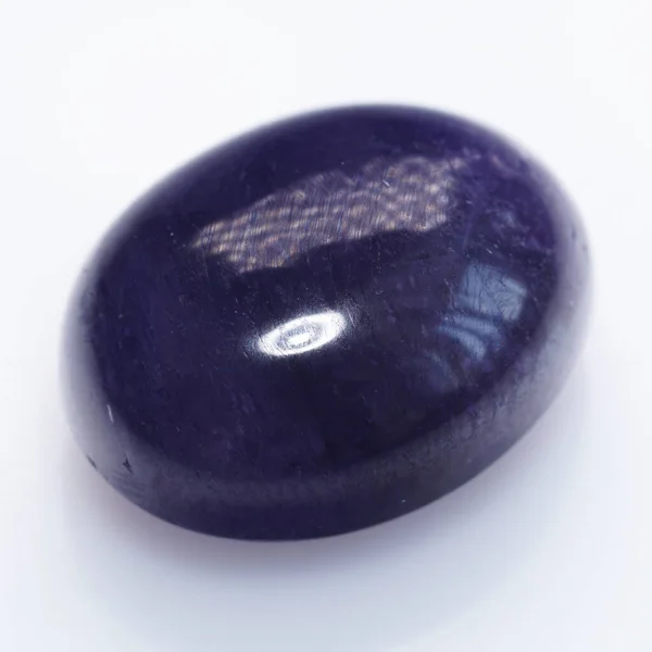 Сапфир из натурального камня. Естественный фиолетовый сапфир на белом фоне — стоковое фото