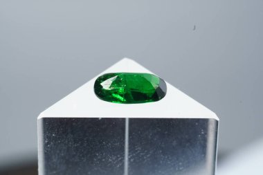 Gri bir arka planda doğal yeşil tsavorit taşları.