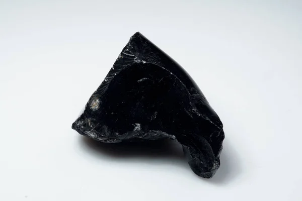 Přírodní černý obsidian kámen na bílém pozadí — Stock fotografie
