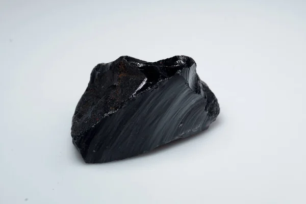 Pierre naturelle d'obsidienne noire sur fond blanc — Photo