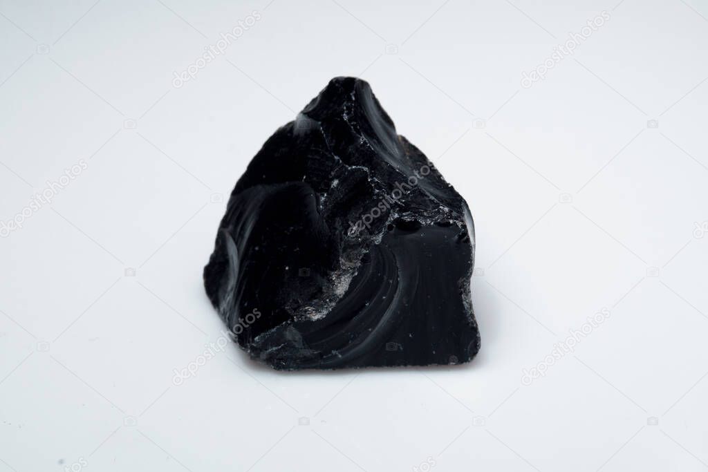 Natural black obsidian stone on background