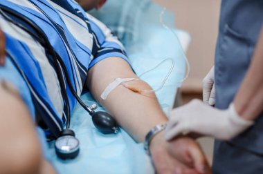 Proktolojik operasyonlar. Nabız oksimetresi. Damardaki bir kateter. Düşüren elinde.