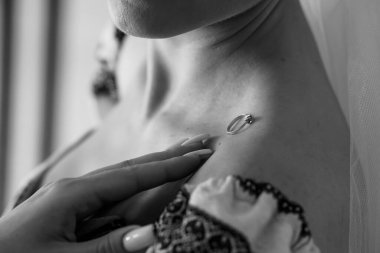 Yakın plan siyah-beyaz bir fotoğraf, narin dantel iç çamaşırlarıyla süslenmiş elmas alyansını nazikçe elinde tutan bir gelini çekiyor. Romantizm ve beklenti taşır