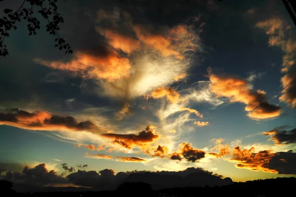 Jogos incomuns de nuvens ao pôr do sol — Fotografia de Stock