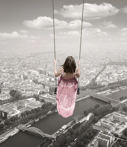 Jonge vrouw op een schommel op de backround van de stad Parijs — Stockfoto