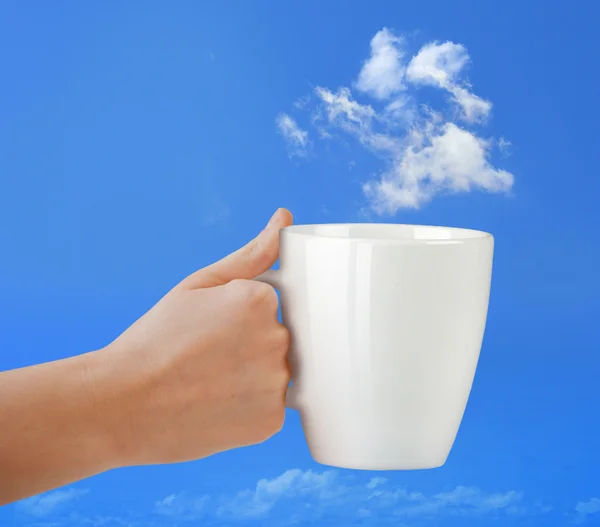 Puchar w ręce na błękitne niebo chmura. — Zdjęcie stockowe