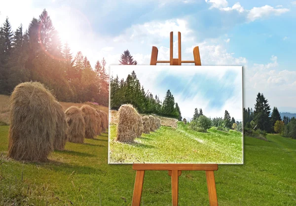 Easel con un disegno su tela su un paesaggio — Foto Stock