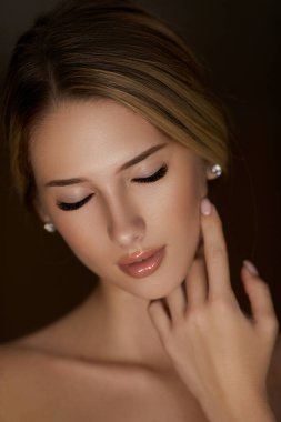 Makyajlı güzel bir kadın. Çiçeklerin güzel beyaz kız arkaplanı. Temiz ciltli, genç ve güzel bir kadının yakından çekilmiş yüzü..