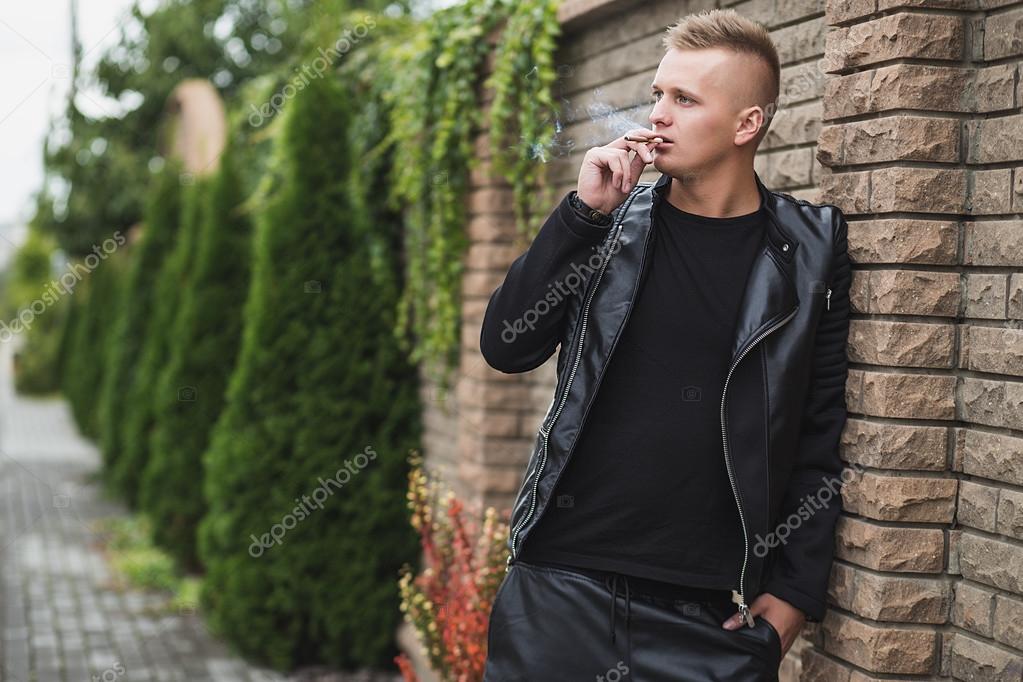 cool young guy smoking a cigar — Stock Photo © AndreyOrletskyy 53841671