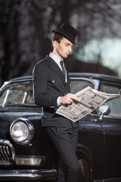 Uomo con una macchina retrò uomo con una macchina retrò. leggere un giornale — Foto Stock
