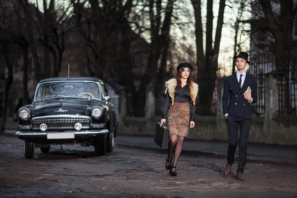 Una pareja joven con un coche retro — Foto de Stock