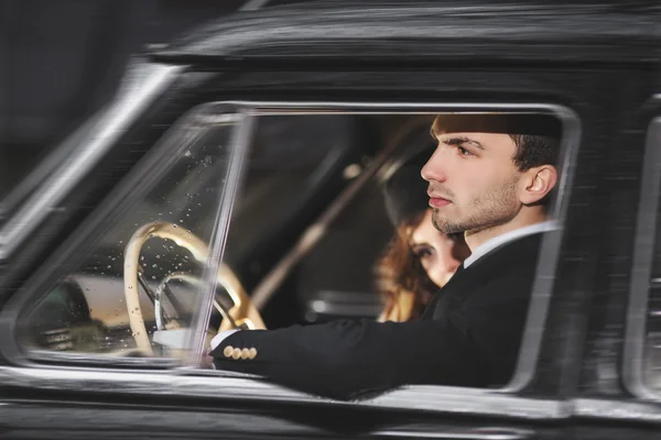 Una pareja joven con un coche retro — Foto de Stock