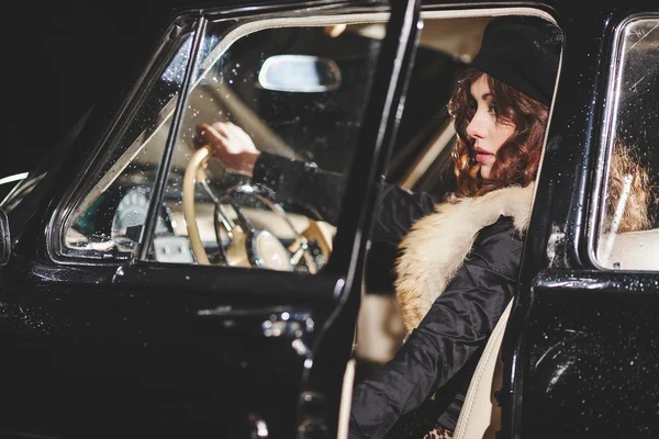 Attractive young girl sitting behind the wheel of a car — Stock Photo, Image