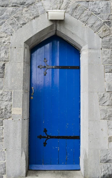 Blauwe deur in kalksteen muur — Stockfoto