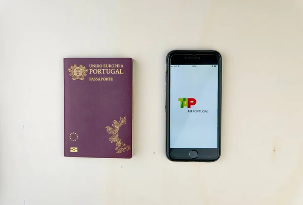 Portekiz pasaportu ve akıllı telefonu ekranda TAP Air Portugal logosunu gösteriyor