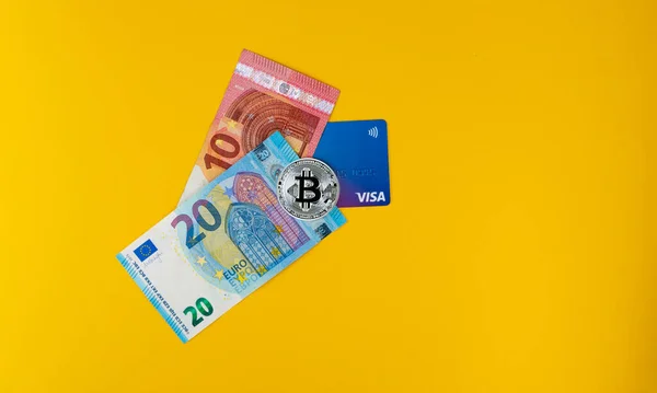  Revolut kredi kartı, euro banknotları ve gümüş bitcoin