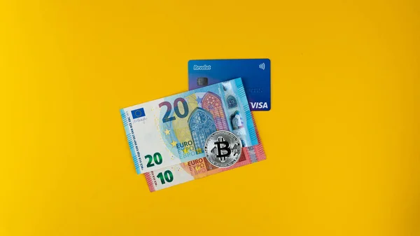  Revolut kredi kartı, euro banknotları ve gümüş bitcoin