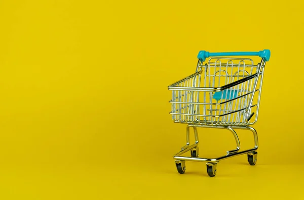 Boş alışveriş arabası sarı arkaplanda izole edilmiş ve metin için boş alan var