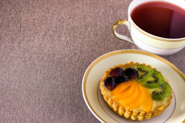 Kırmızı çayla kaplı bir tabakta tatlı küçük pasta. Boş alanı kopyalayan fotoğraf.