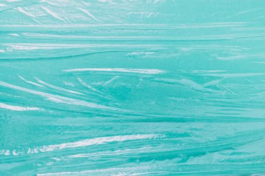 Yeşil kağıt arka planda katlanmış düzensiz selofan yemek film folyosu ile model şablonu.