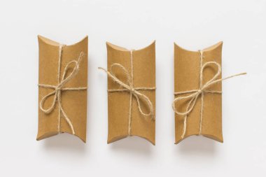 Üç hediyeli basit kompozisyon beyaz arka planda paketlenmiş el işi kağıt kutularını sunar..
