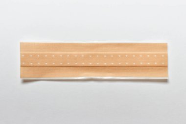 Beyaz arka planda ahşap kaplaması için uzun bir tıbbi bej antiseptik alçı..