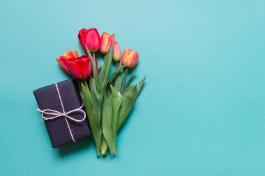 Nane yeşili arka planda hediyeli bir buket kırmızı lale. Boş alanı kopyalayan fotoğraf.