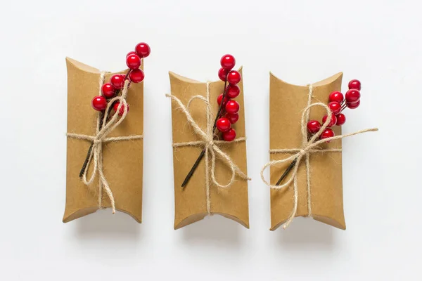 Три Коробки Подарков Обернуты Пакетной Нитью Украшены Ветвями Красных Ягод — стоковое фото