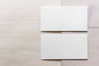 Ahşap arka planda iki boş kartviziti olan bir model şablonu.