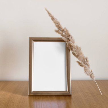 Dikey boş fotoğraf şablonu modeli altın parlak çerçeve ve kuru kabarık dal.