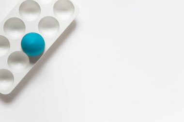 Basit, minimalist Paskalya tebrik kartı. Yumurta plastik standı ve bir mavi yumurta. Boş alanı kopyalayan fotoğraf.