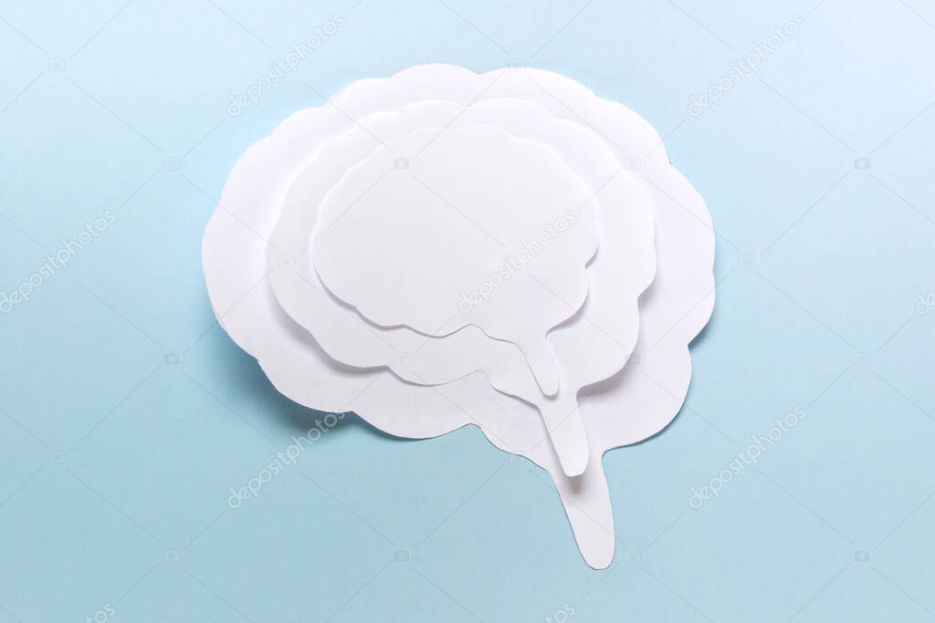 Simple paper concept with brain outline silhouette on blue background.